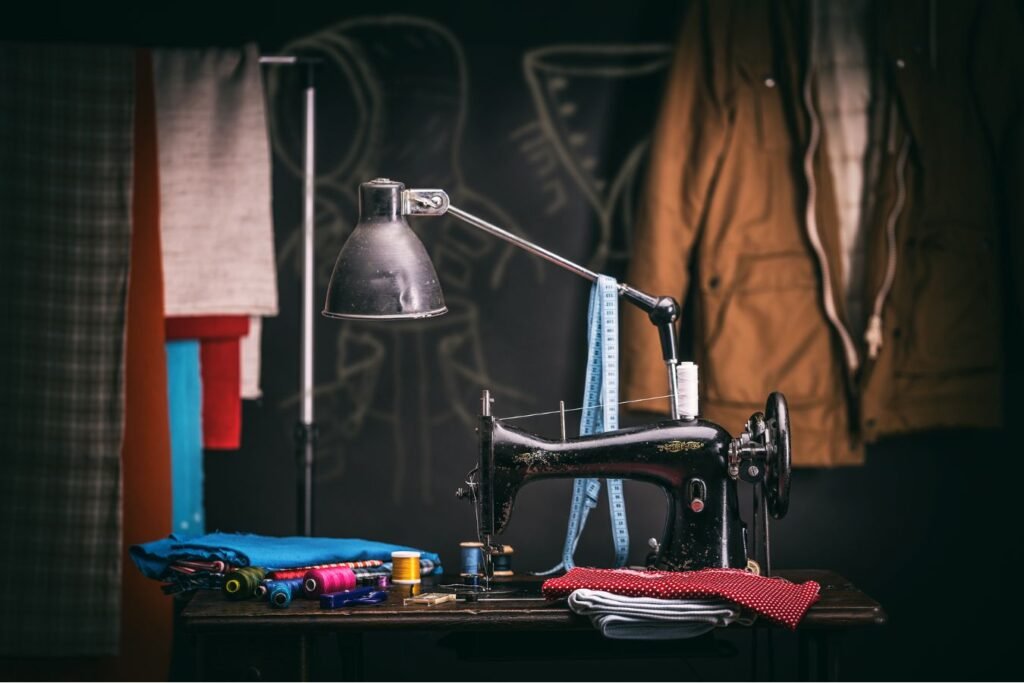 Macchina da cucire vintage in laboratorio sartoriale con tessuti colorati e metro da sarta. dmplus. dm+. Damiano Macaluso